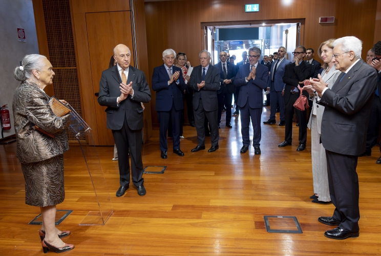 Il Presidente Sergio Mattarella assiste alla scopertura della targa da parte della Sig.ra Barucci, in occasione della  cerimonia di intitolazione di una Sala delle Scuderie di Palazzo Altieri in memoria del Presidente emerito dell’Associazione Bancaria italiana, Prof. Piero Barucci
