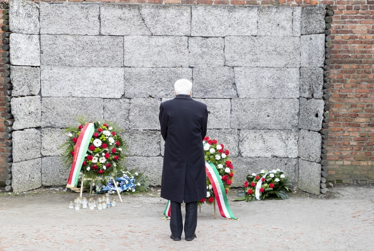 Il Presidente della Repubblica Sergio Mattarella depone una corona presso il muro delle esecuzioni, in occasione della visita al Museo di Auschwitz - Birkenau